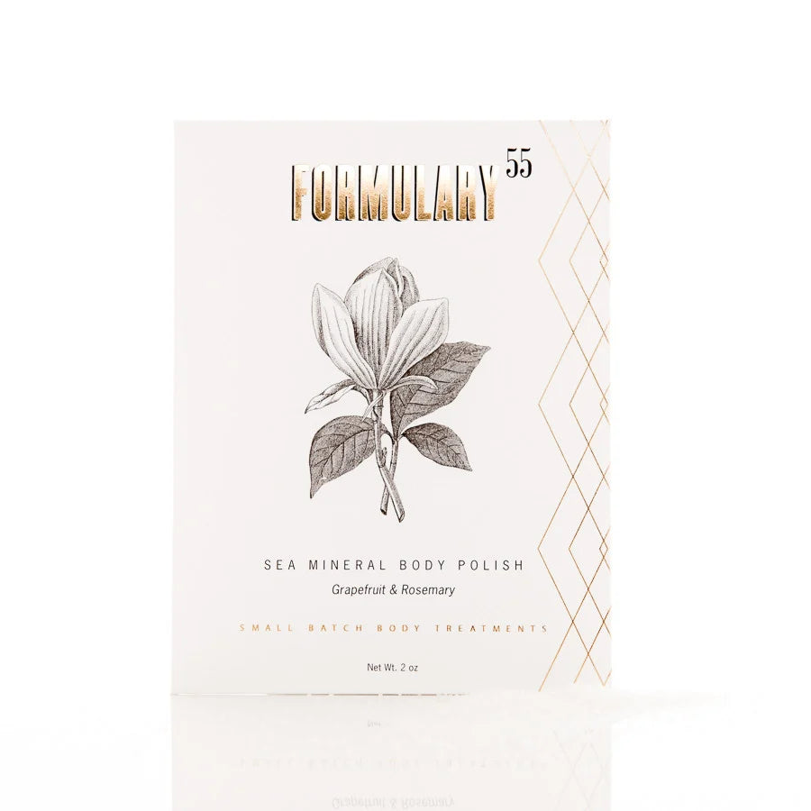 A single product box for 'Furnimulary' Sea Mineral Body Polish, featuring a botanical illustration of a magnolia flower on a warm off-white background with gold foil lettering and geometric accents.
