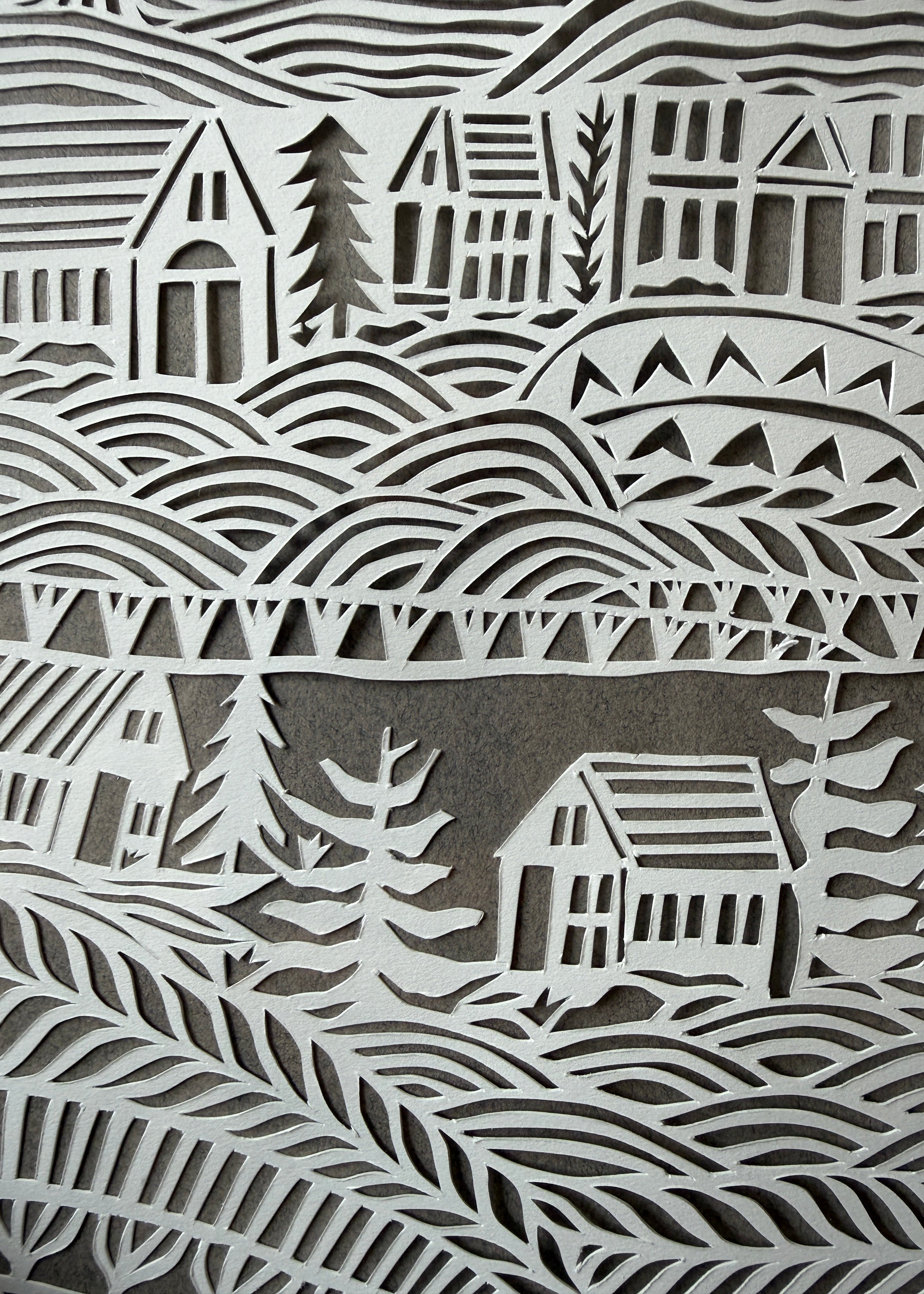 Close-up of Jennifer Judd-McGee's original "What Connects Us" papercut, highlighting the intricate hand-cut details and layered archival paper.