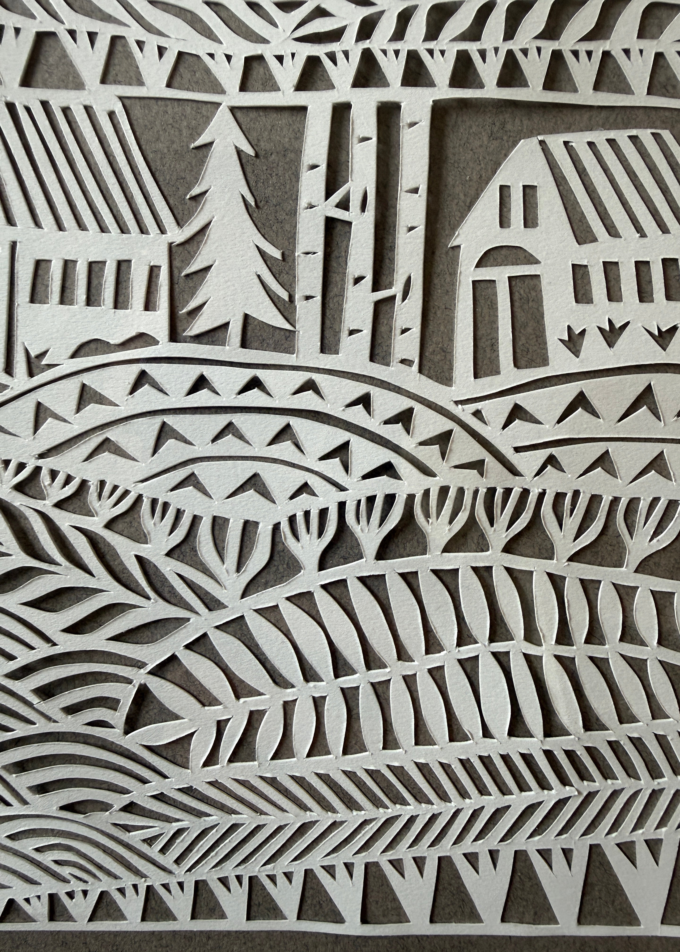 Close-up of Jennifer Judd-McGee's original "What Connects Us" papercut, highlighting the intricate hand-cut details and layered archival paper.