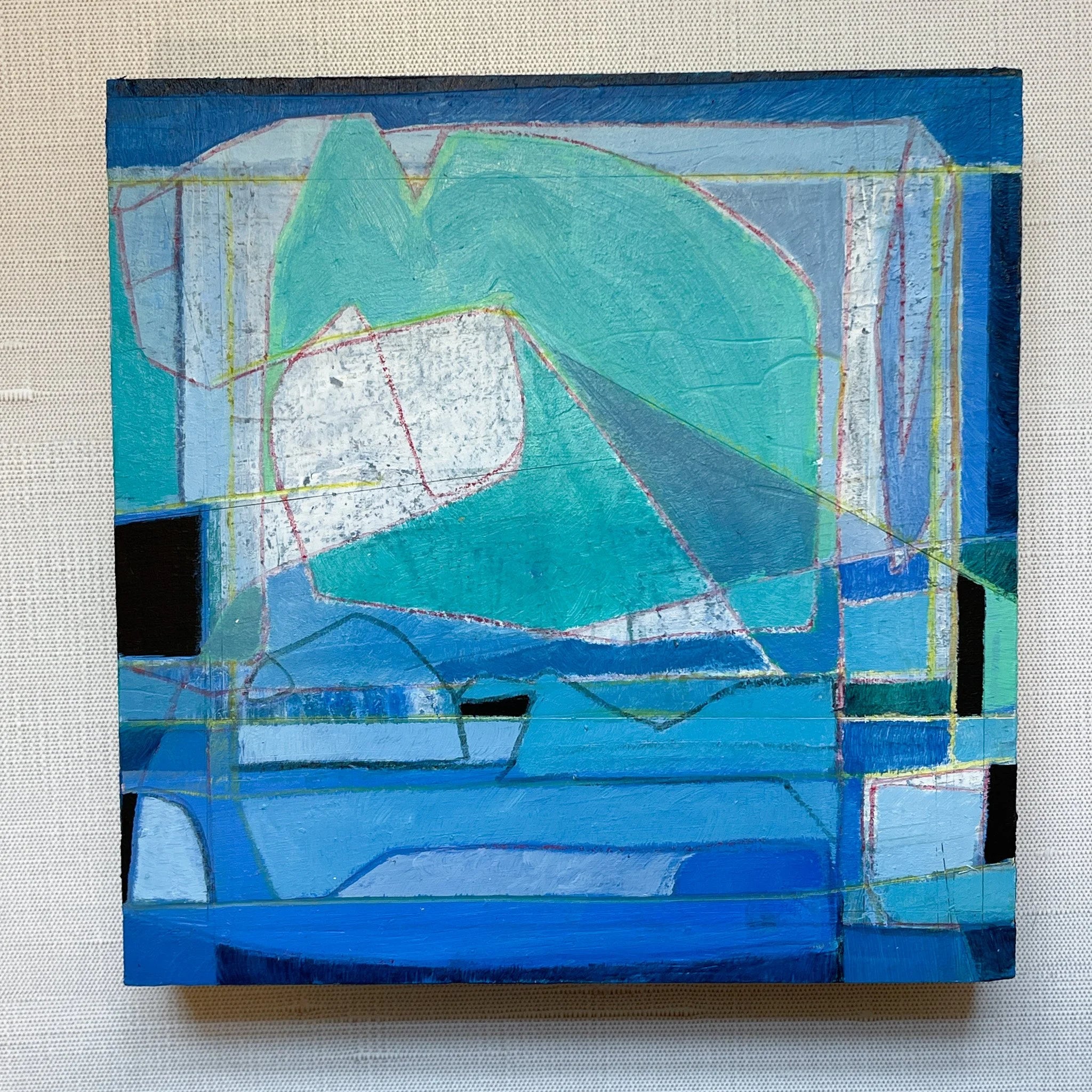 Abstract art piece with geometric shapes in blue tones on a textured beige background
