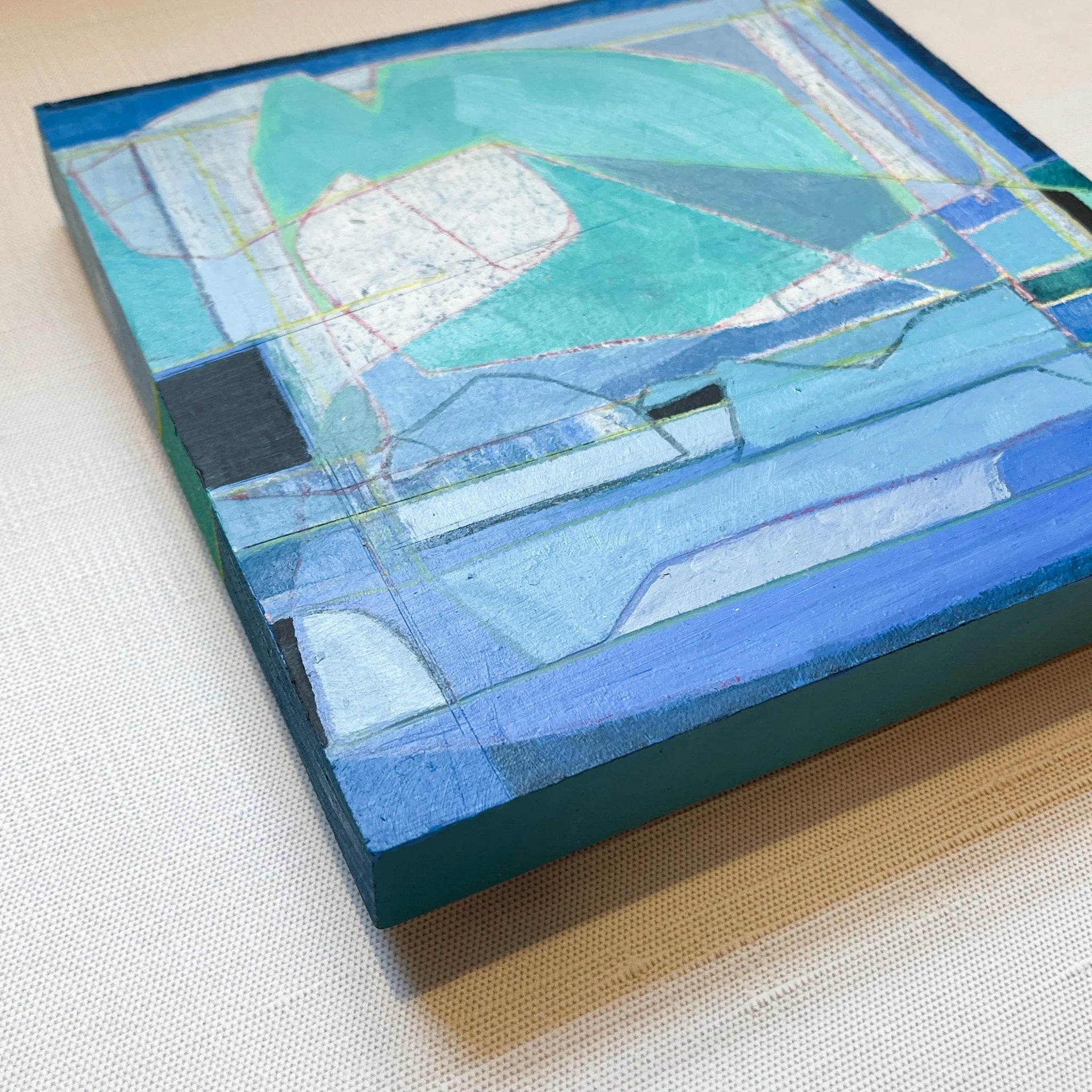 Abstract artwork with blue and green tones on a textured surface