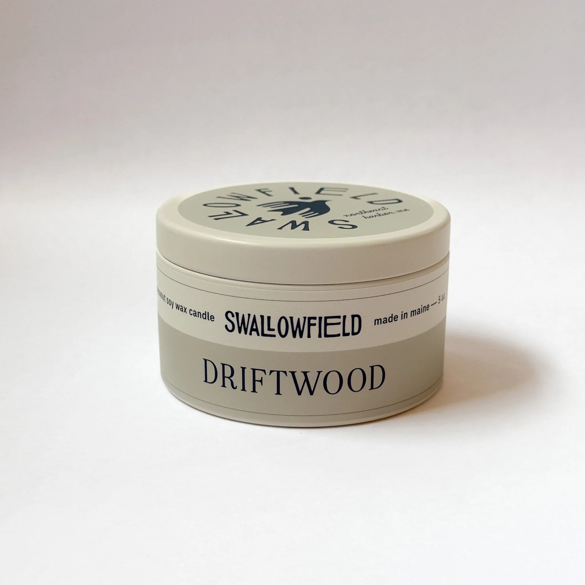 Candle jar labeled 'Swallowfield Driftwood' on a white background