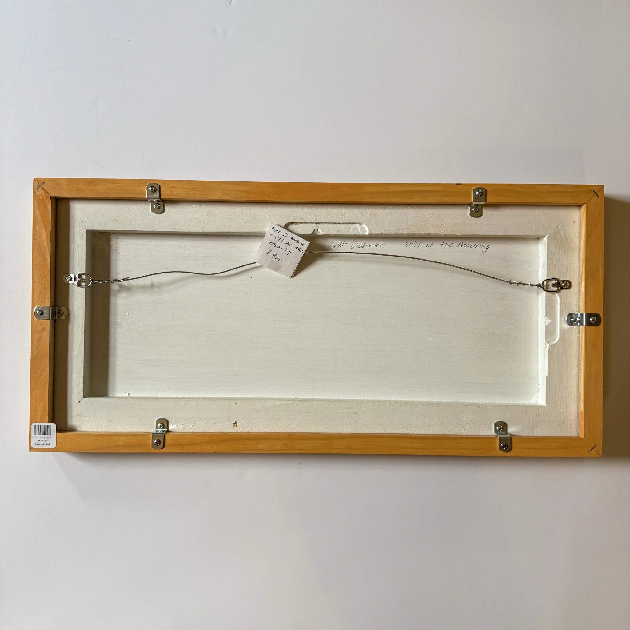 Wooden frame with a white canvas inside on a plain wall