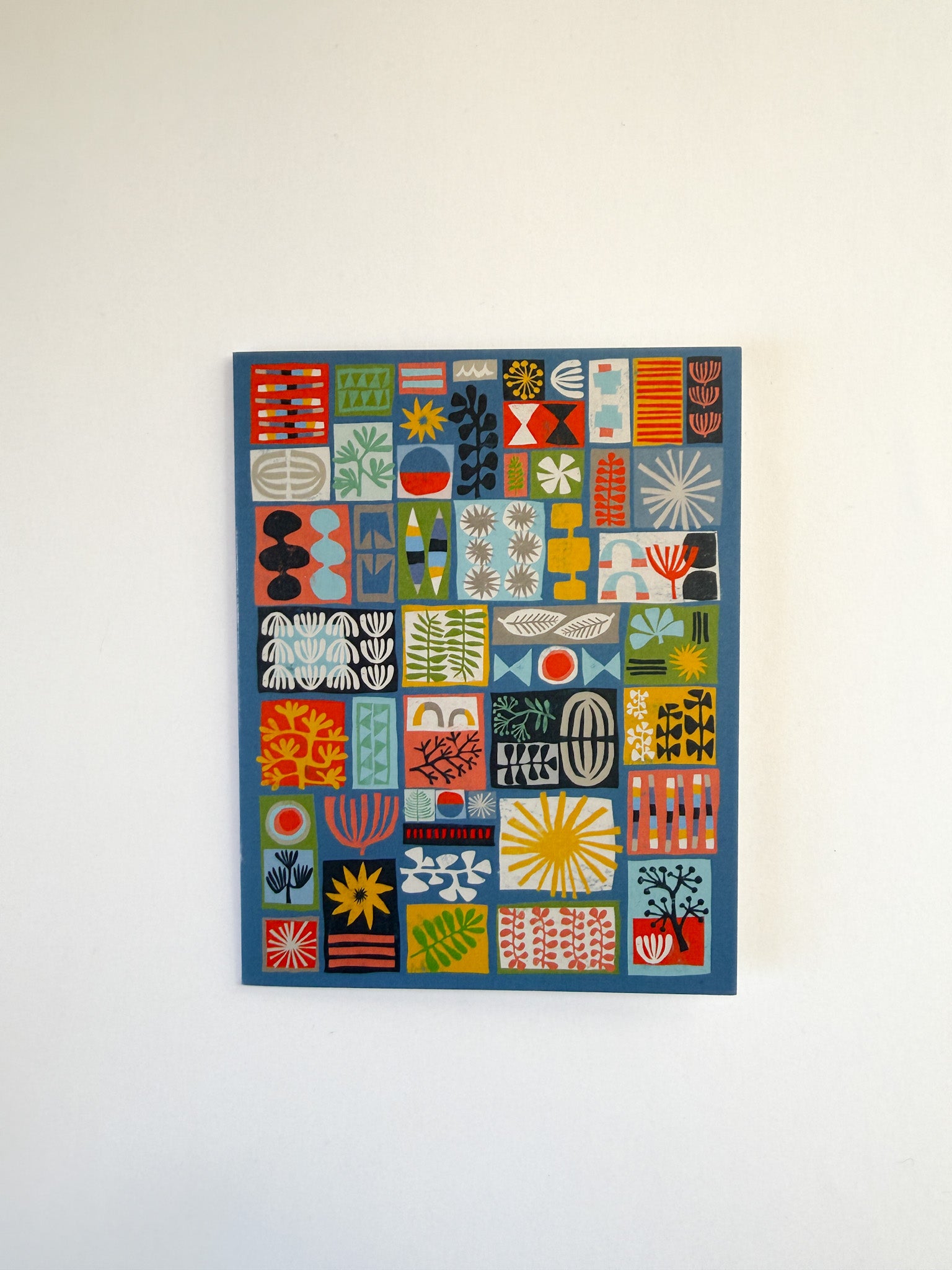 Colorful abstract patterned wall art on a white wall