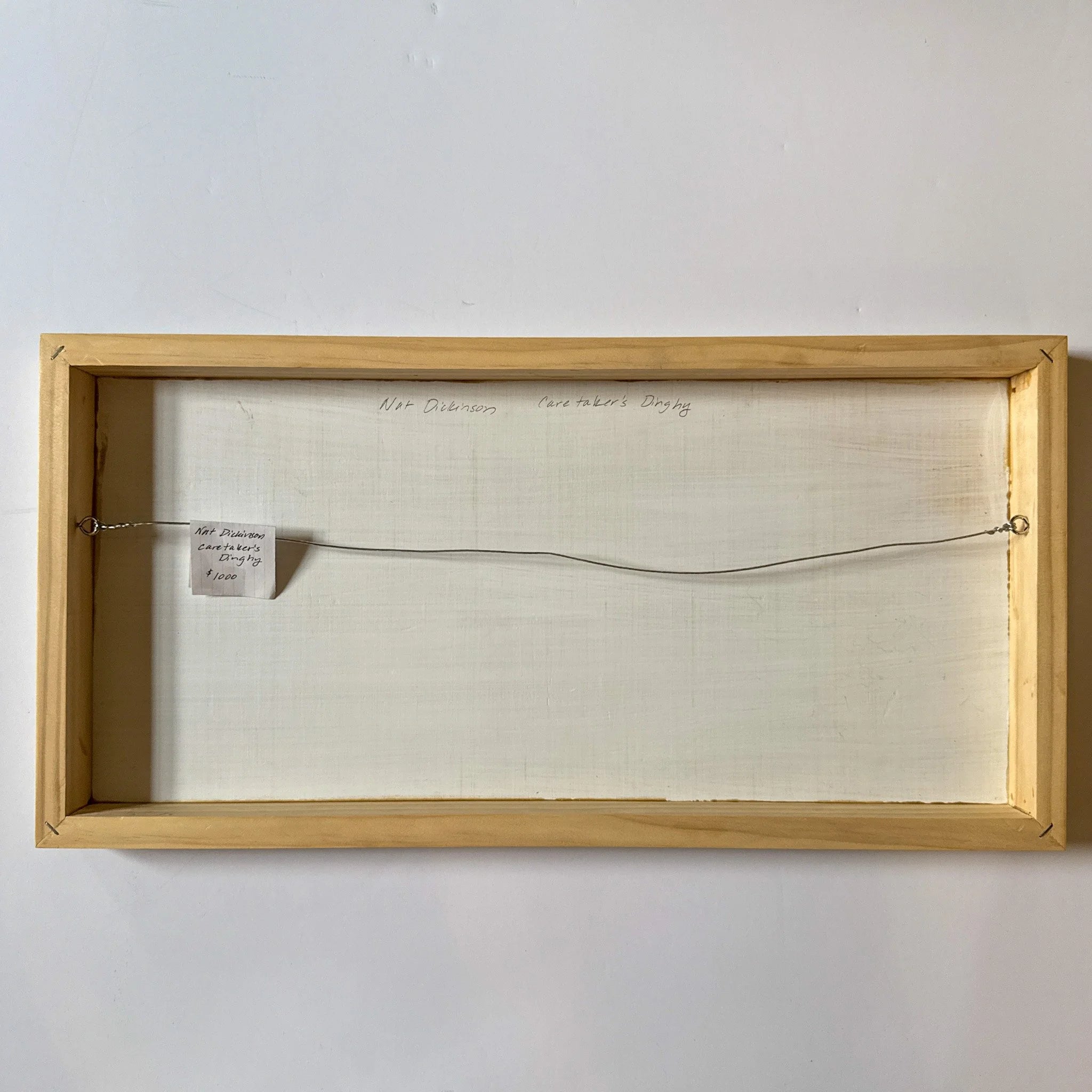 Wooden frame with a piece of paper inside on a white wall