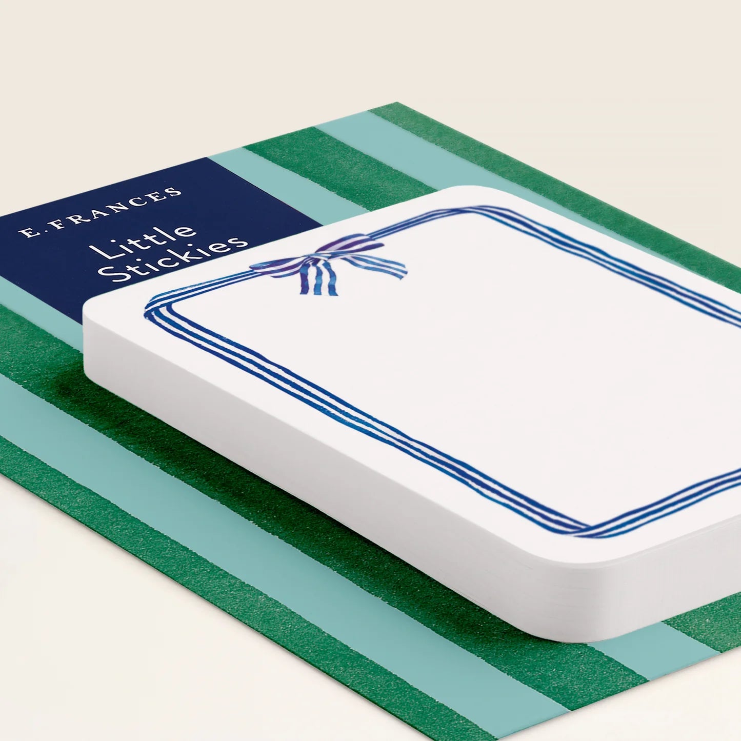 White card with blue ribbon design on a green and blue striped background