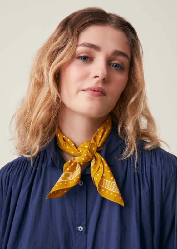 Model wearing Allegra N'843 Moismont Scarf in Farandole as a neckerchief, front view.