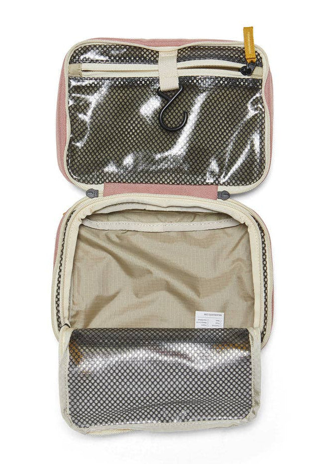 Interior photo of the Toiletry Bag featuring open clear mesh zipper pockets and a hook for hanging.